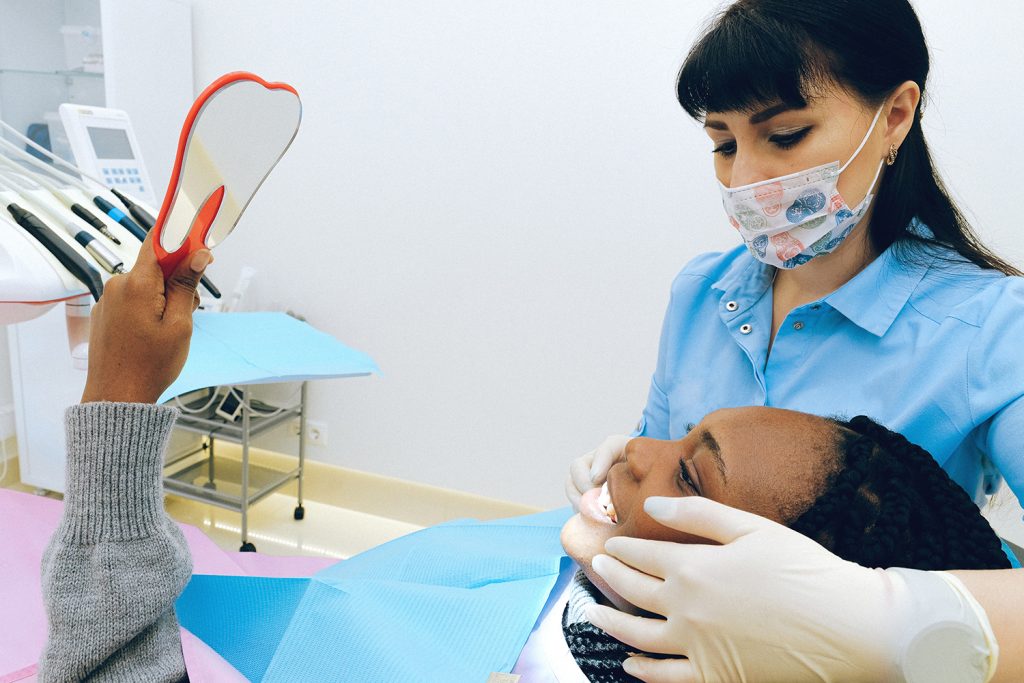 Woman looks in mirror after dental treatment